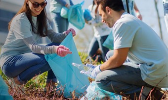 Volunteers actively collecting litter in a park, promoting community cleanliness and environmental stewardship.