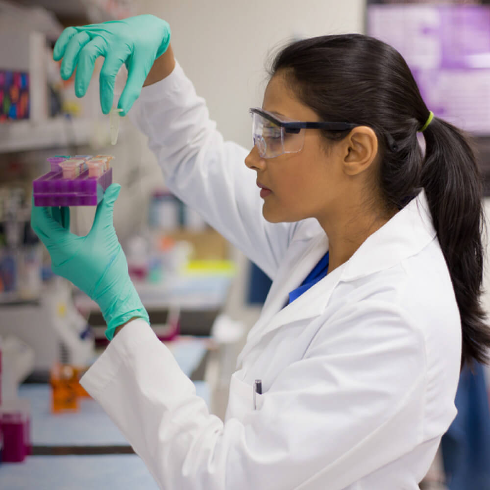 A woman in a lab coat inspecting medical equipment