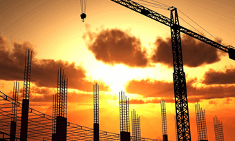 A crane silhouetted by the setting sun in the background