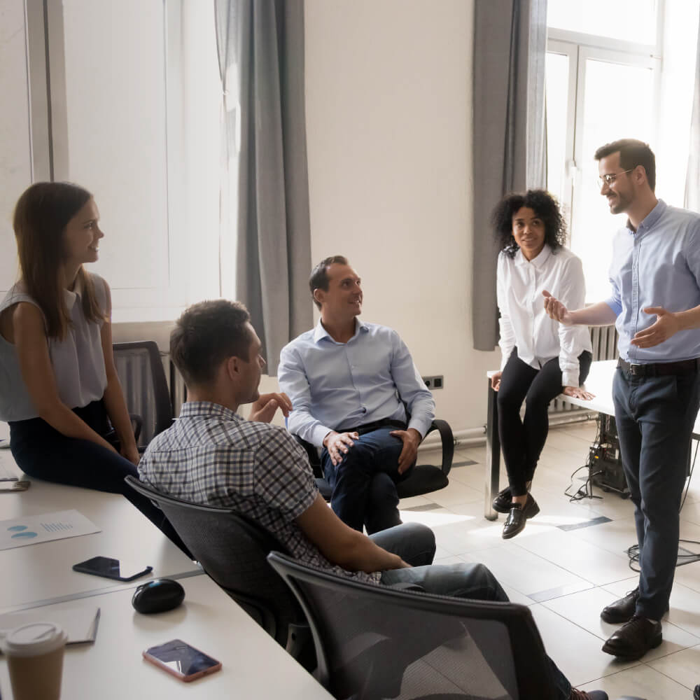 A group of colleagues conversing by their desks