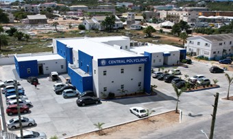 Aerial shot of a blue building with cars arranged in front