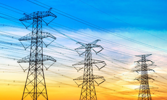 Silhouetted electricity towers against a vibrant sunset