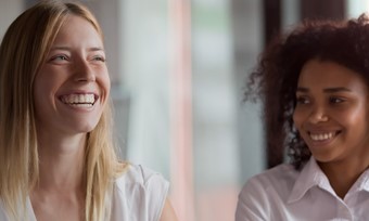 Two women happily conversing in an office